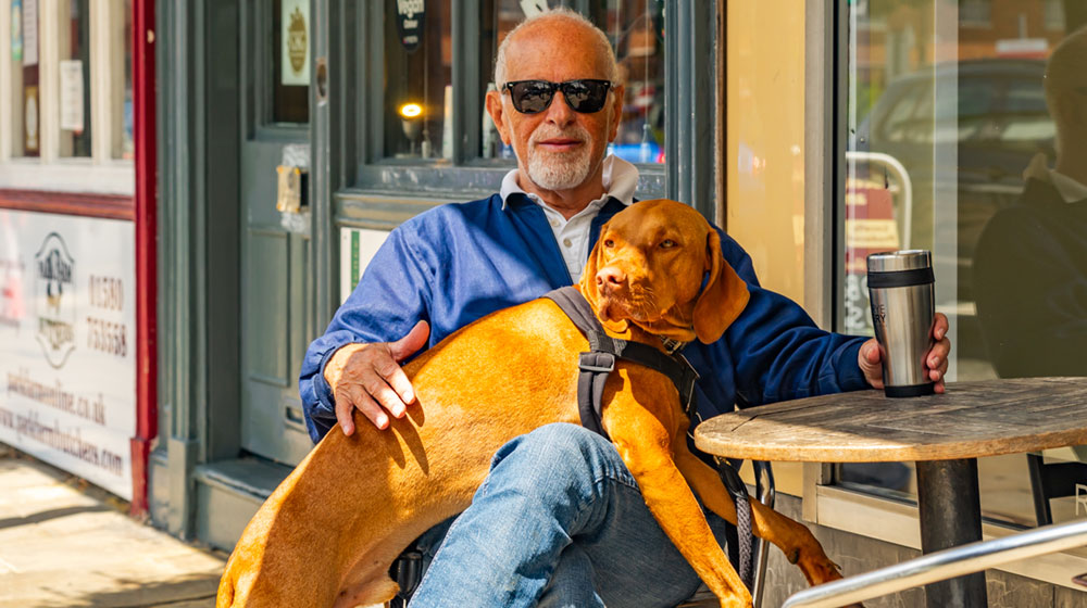 Dog with a male sitting outside a cafe Dog with a male sitting outside a cafe