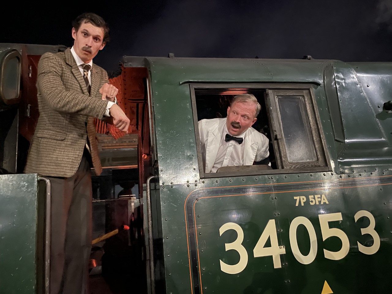 Two men acting on the footplate of a steam train