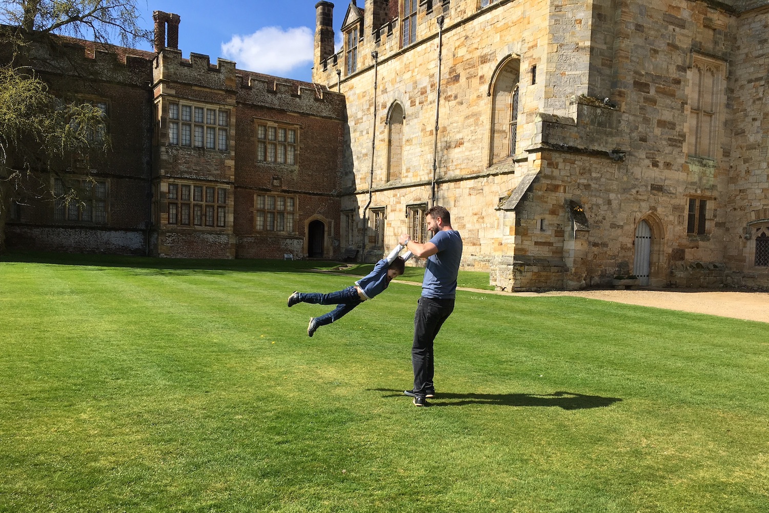 A dad and son playing together within Penshurst Place's grounds