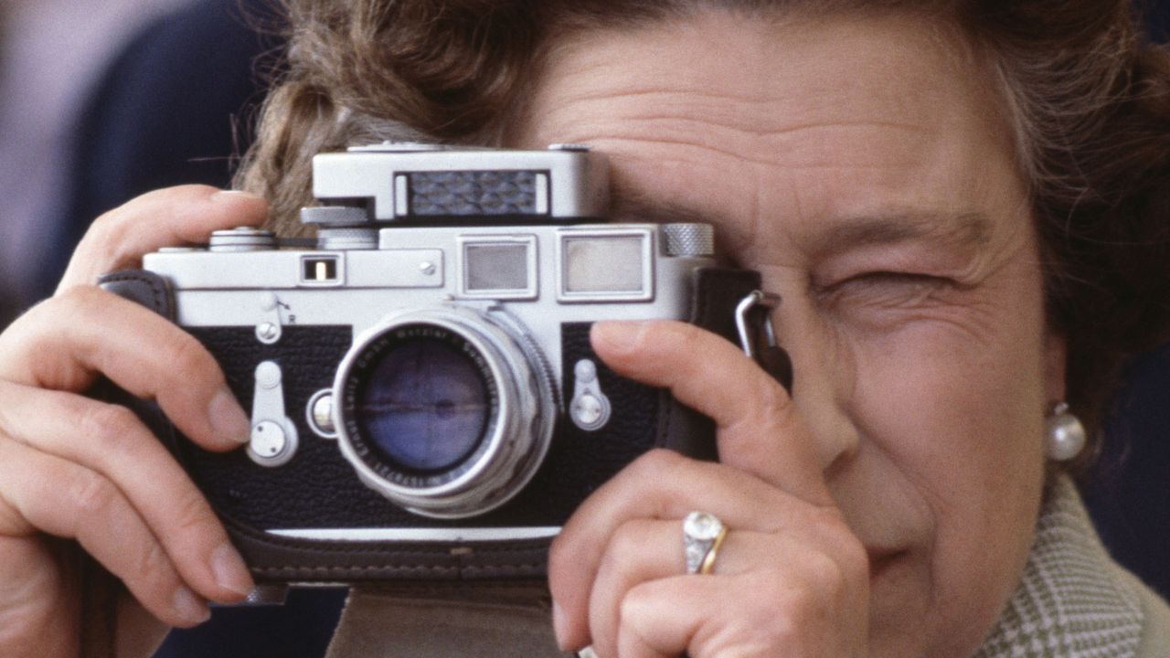 Queen Elizabeth II using a camera